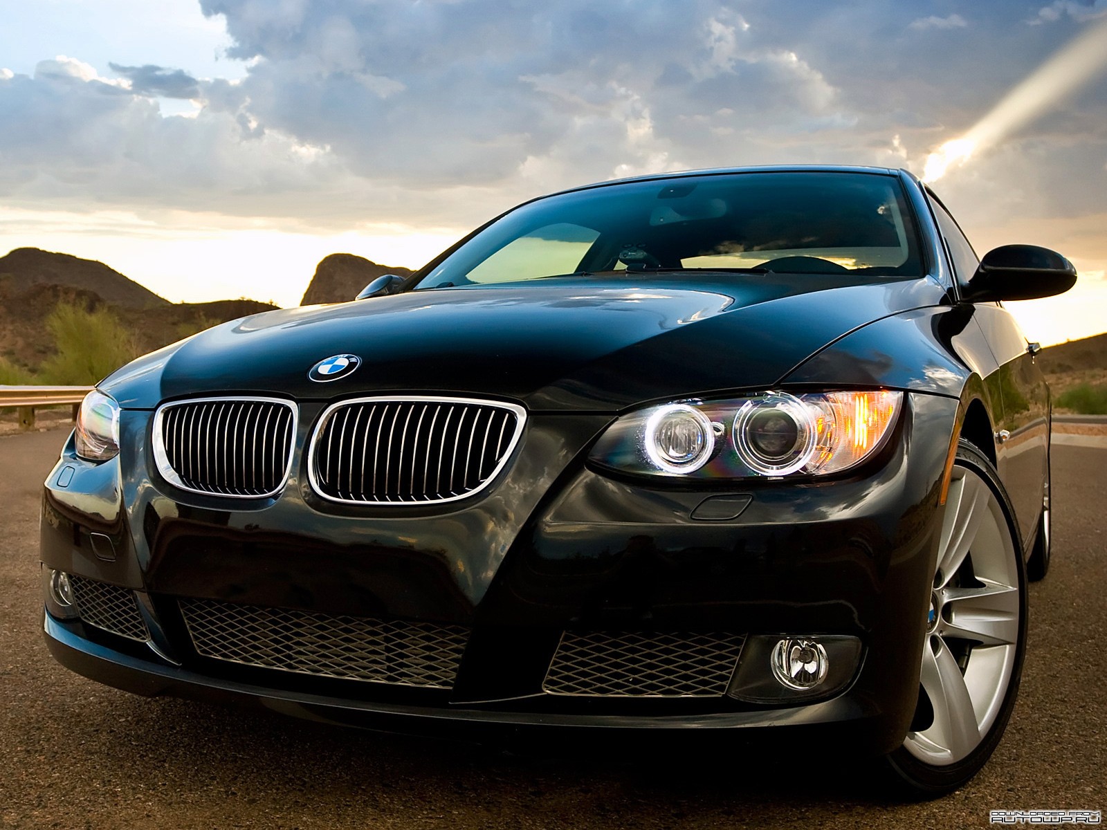 Black BMW in desert sunset