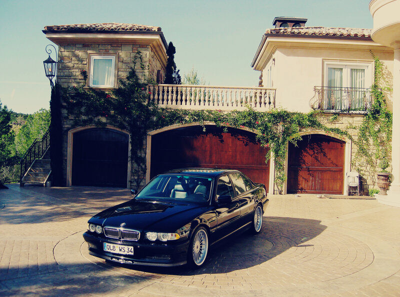 Black BMW in front of villa