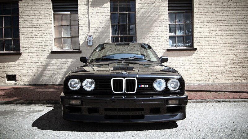 Black BMW M3 in front of brick building