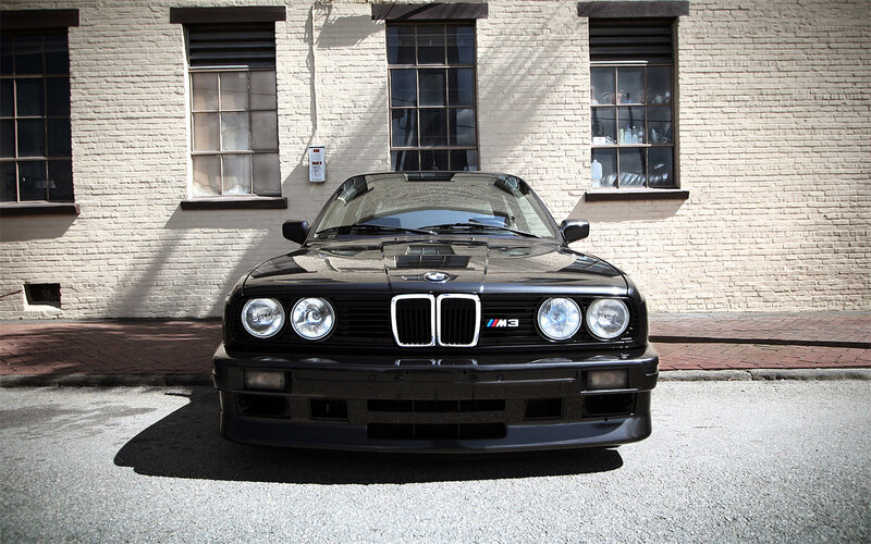 Black BMW M3 in front of brick building