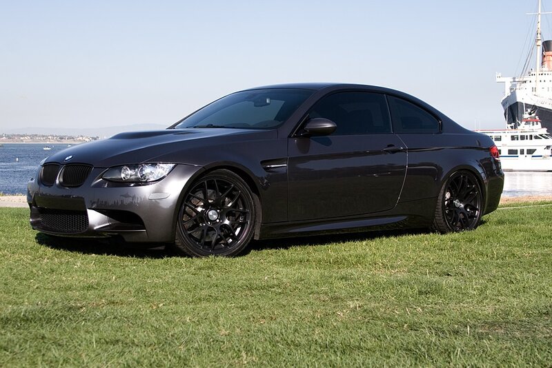 Black BMW M3 on grass by water