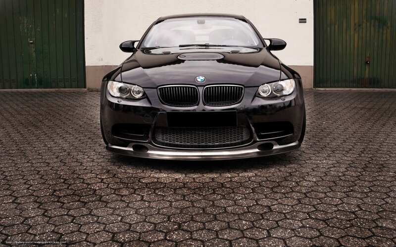 Black BMW M3 parked on cobblestones
