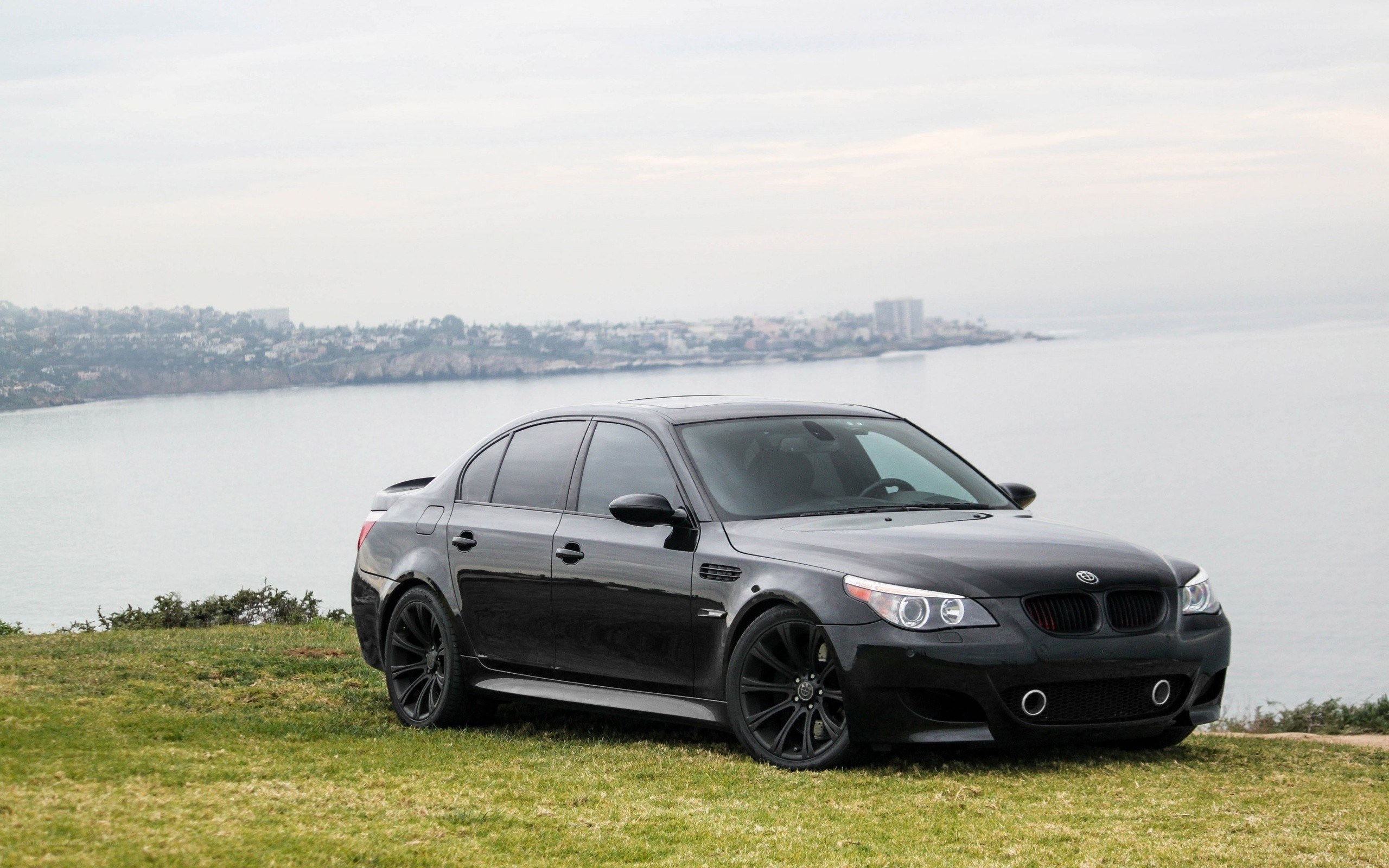 Black BMW M5 by the coast