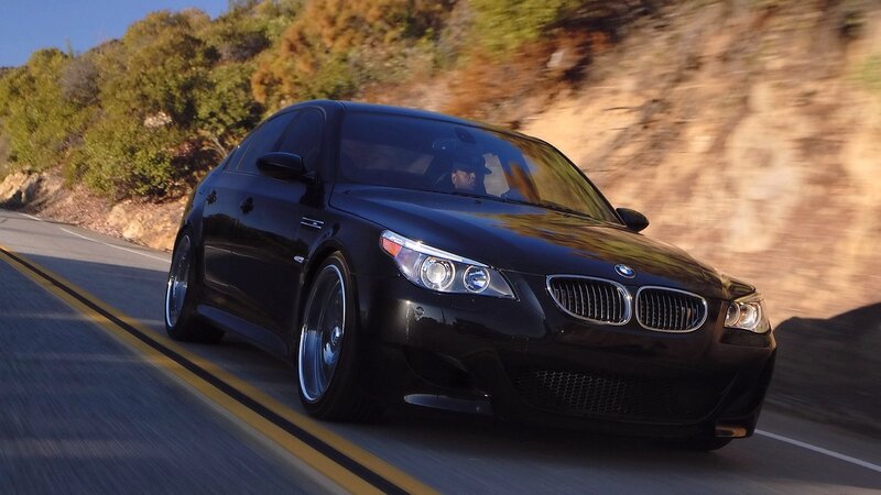 black bmw m5 driving on road