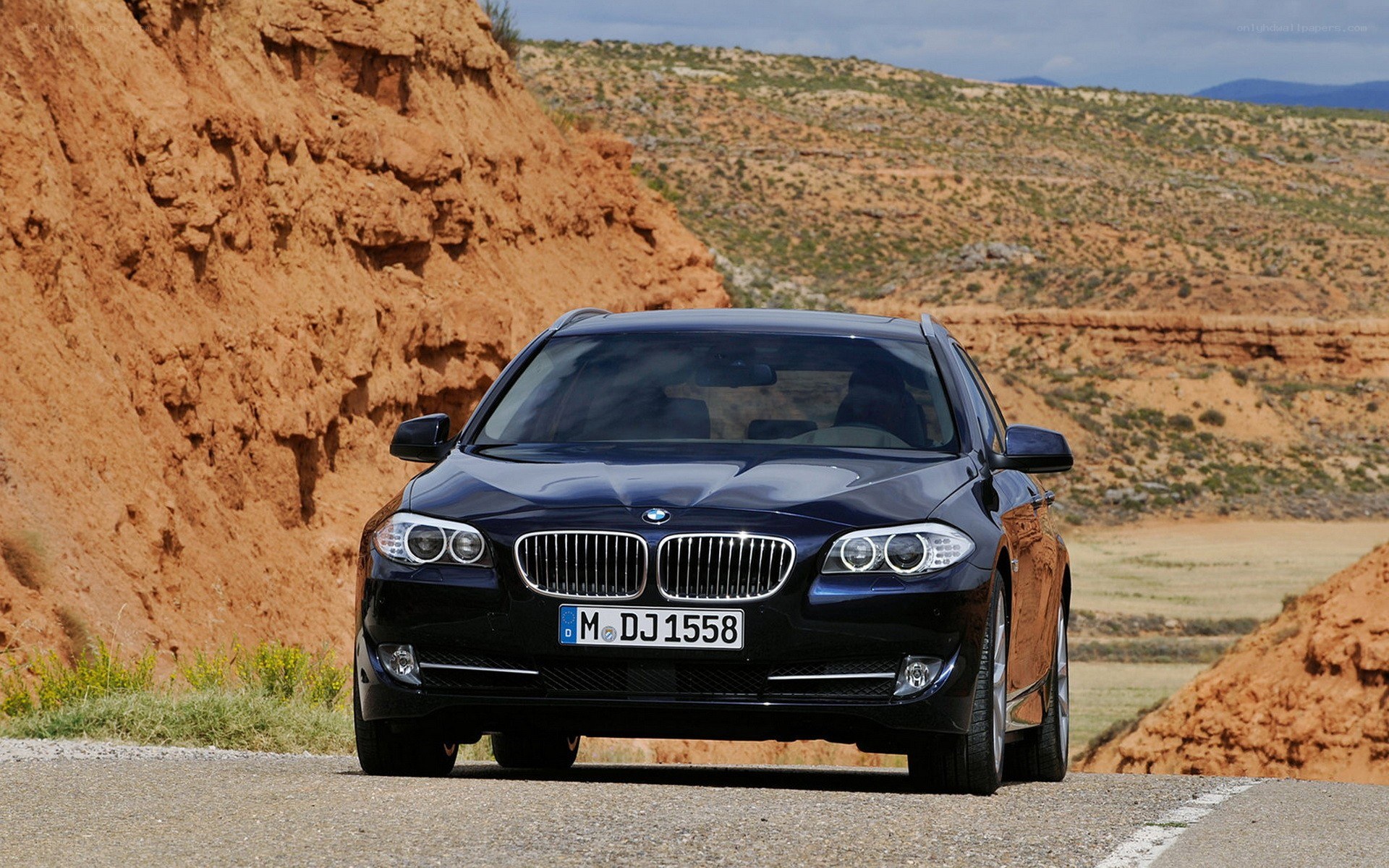 Black BMW on a desert road
