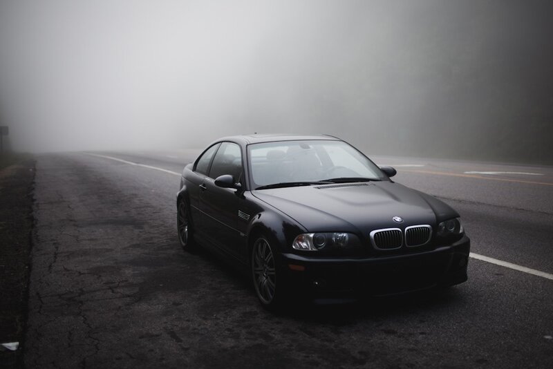 Black BMW on a foggy road