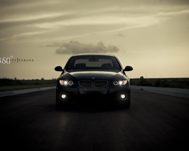 Black BMW on a road at dusk