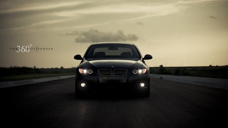 Black BMW on a road at dusk