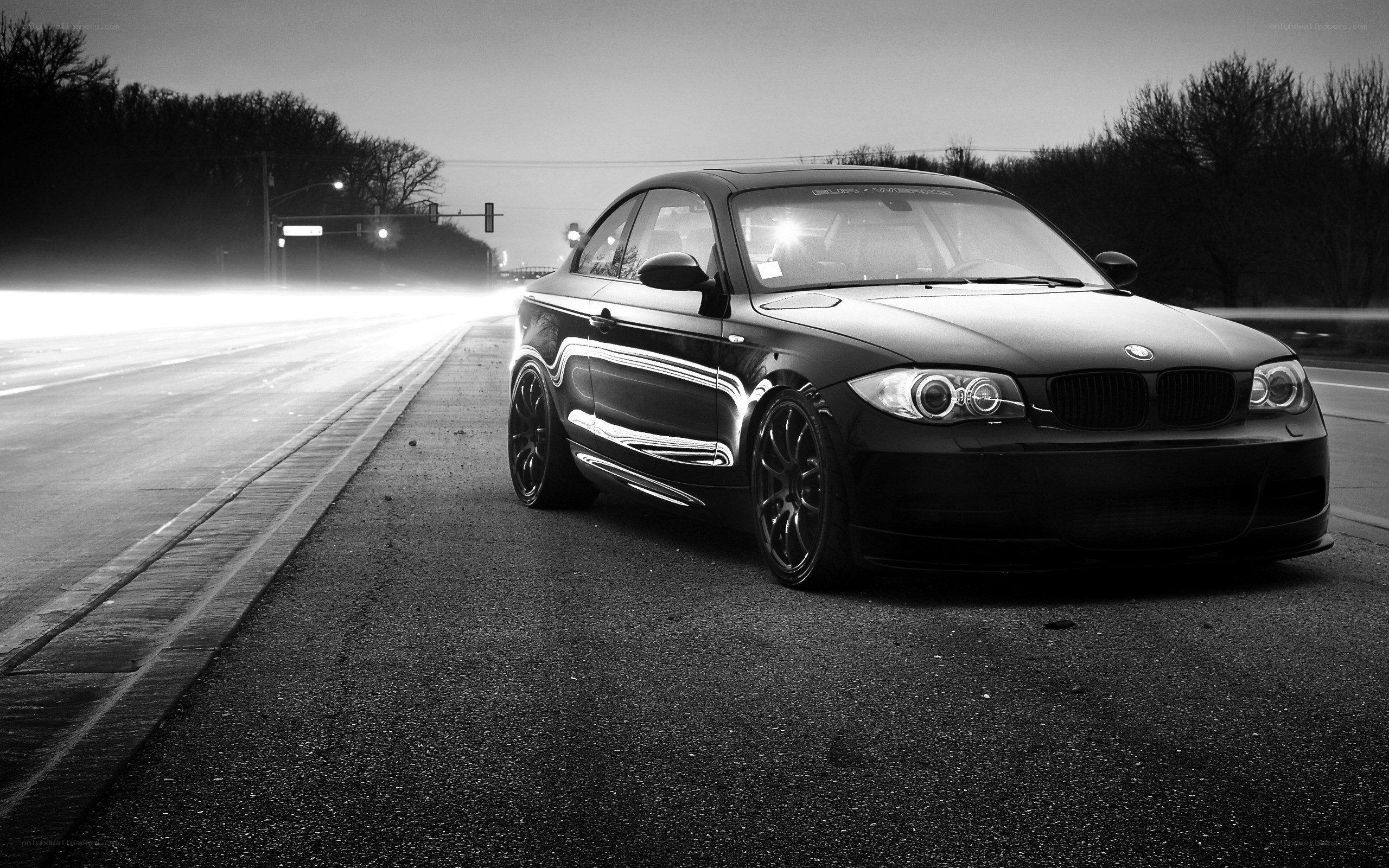 Black BMW on a road at night