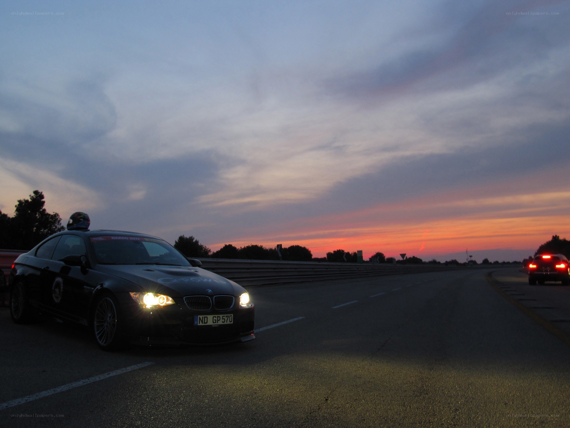 Black BMW on racetrack at dusk
