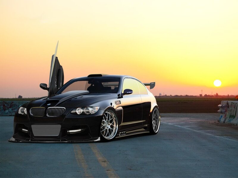 Black BMW on racetrack at sunset