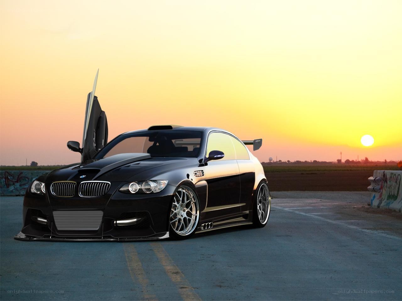 Black BMW on racetrack at sunset