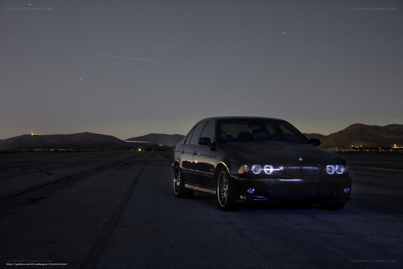 Black BMW on runway at night