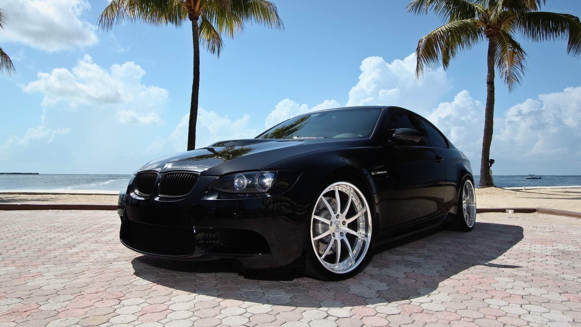 Black BMW on tropical beach