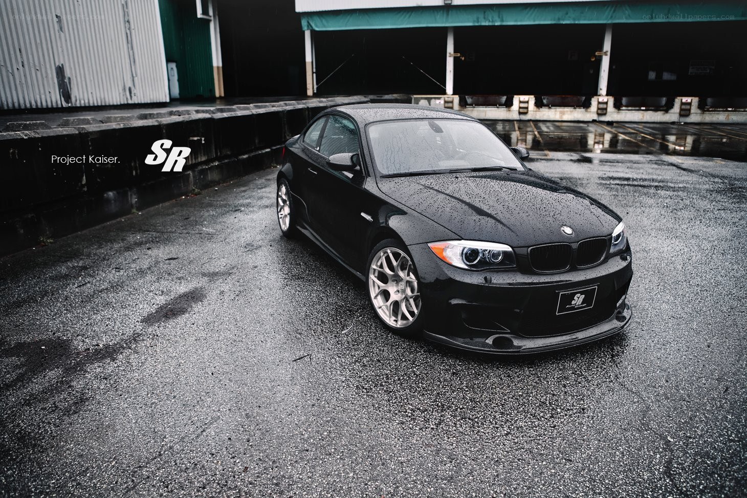 Black BMW on wet pavement