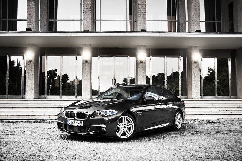 Black BMW parked in front of building