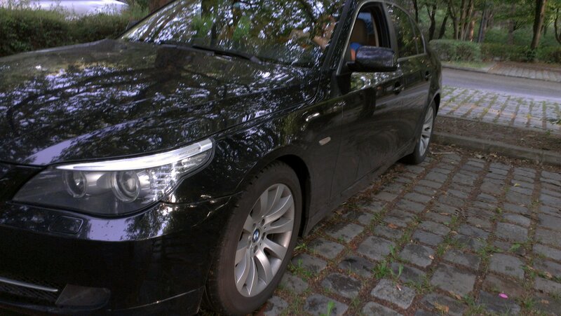 black bmw parked on cobblestones