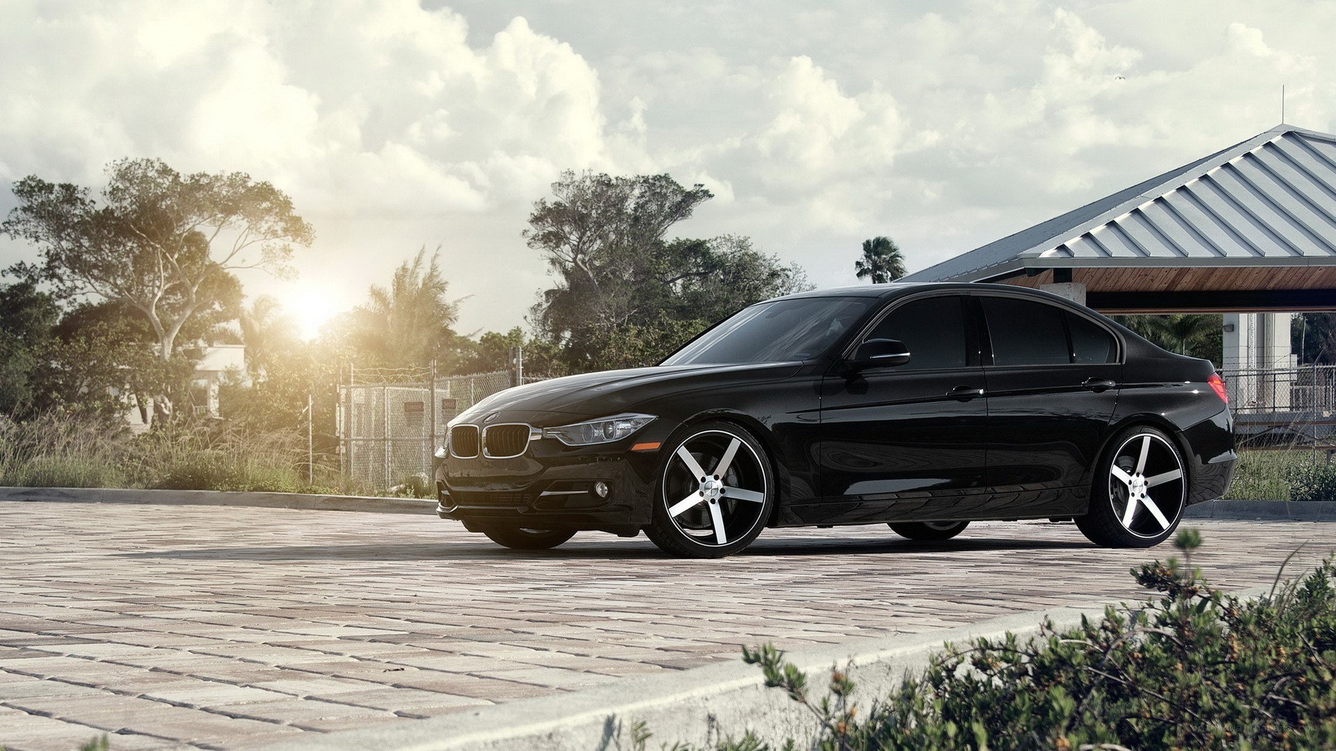 Black BMW sedan on cobblestone