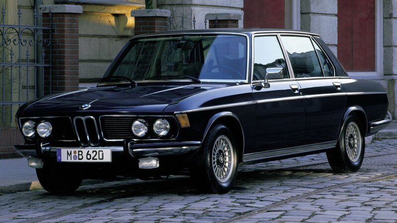 Black BMW sedan on cobblestones