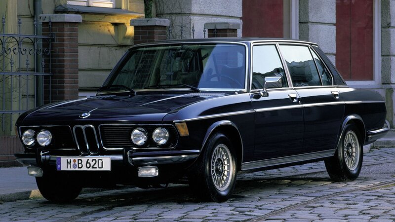 Black BMW sedan on cobblestones