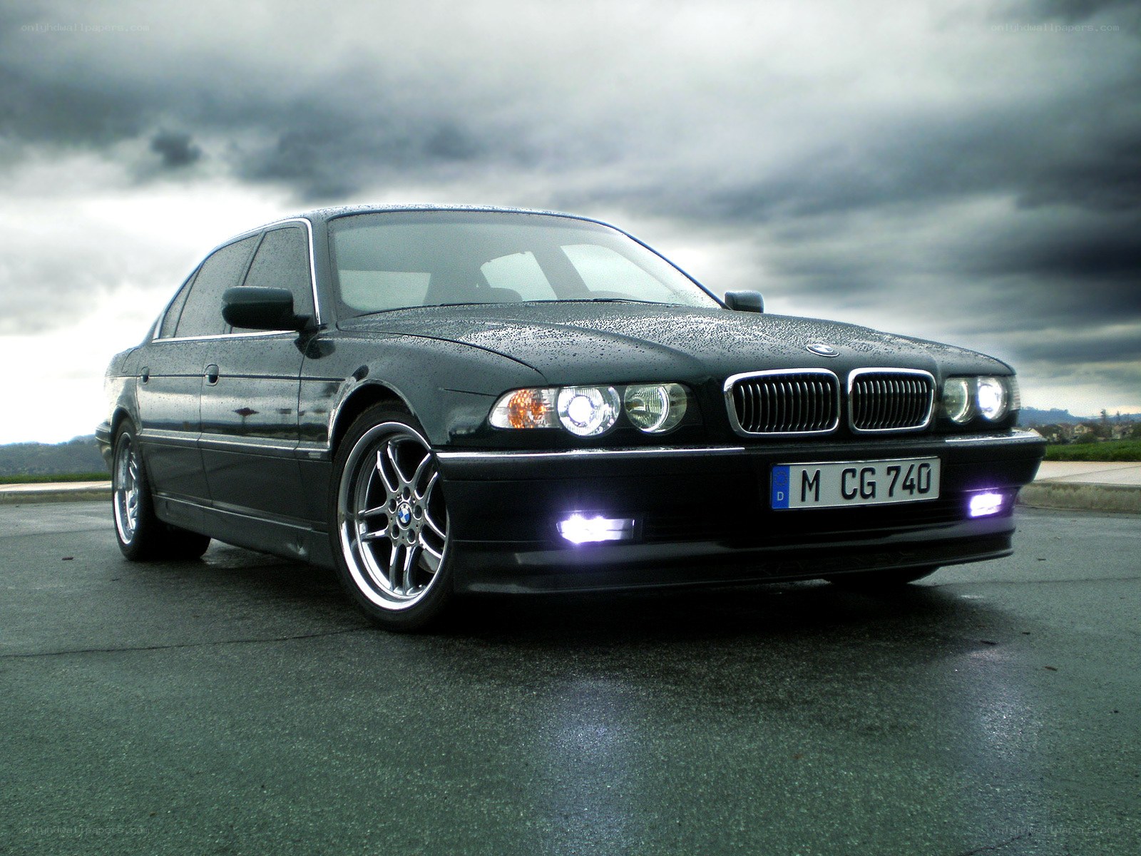 black bmw sedan on wet pavement