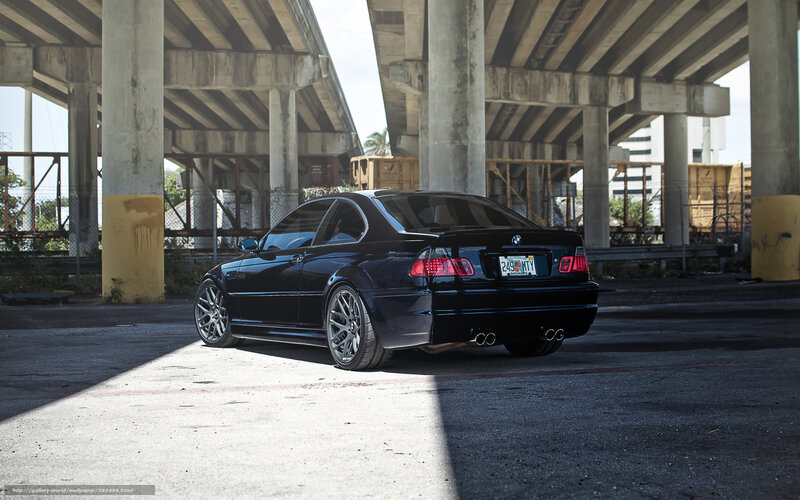 Black BMW under highway overpass