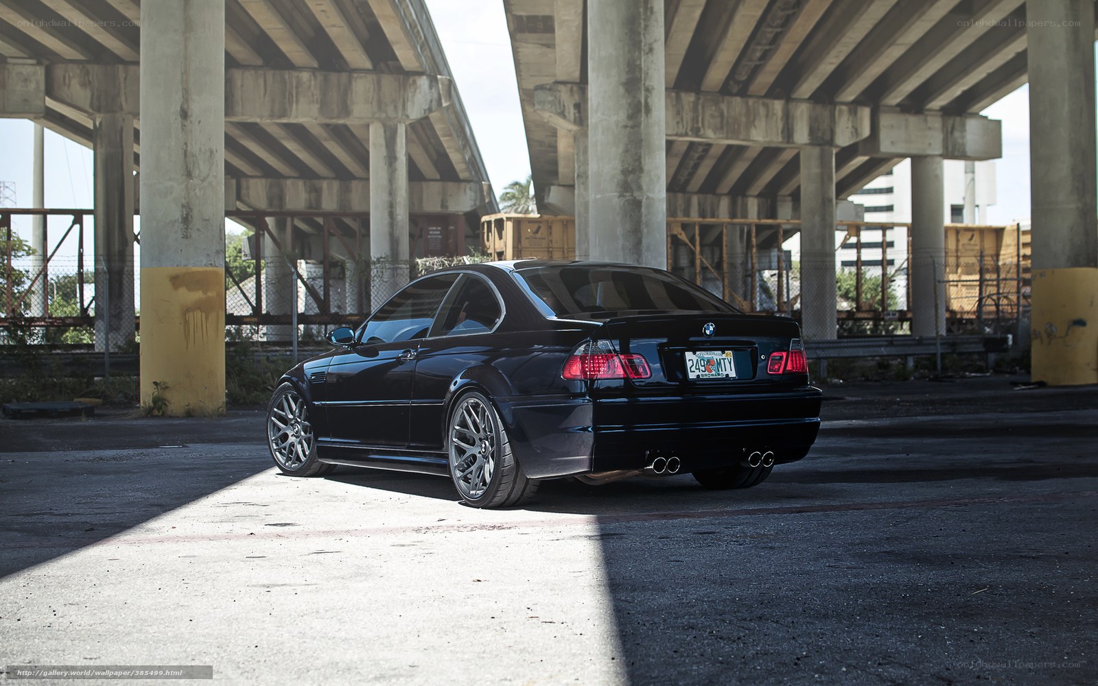 Black BMW under highway overpass