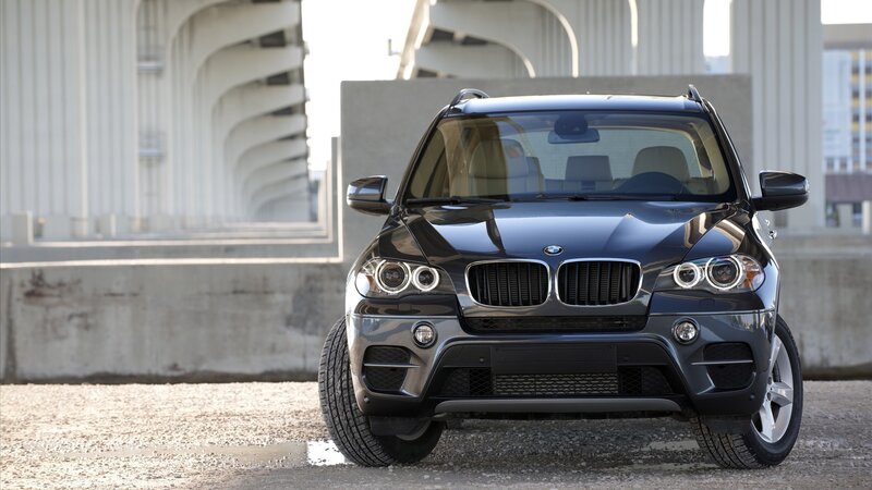 Black BMW X5 parked under bridge
