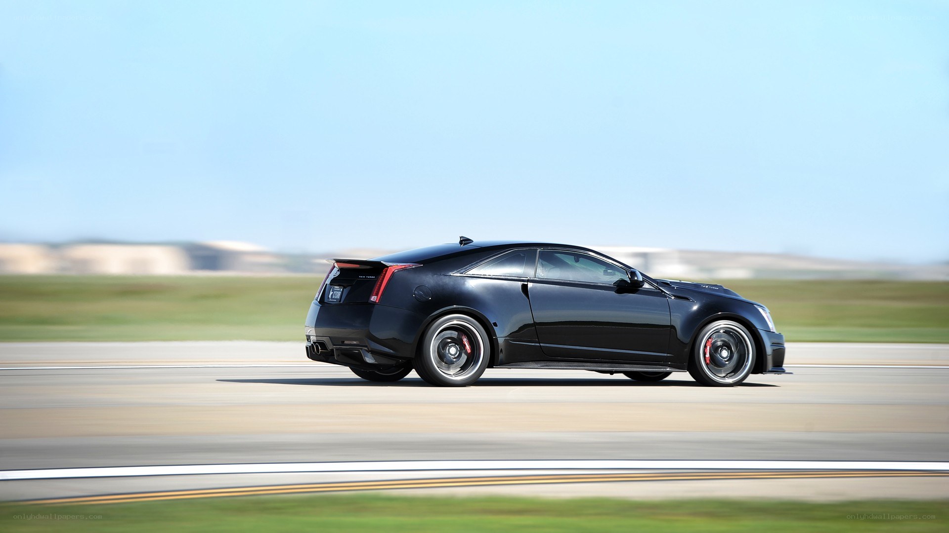 black cadillac coupe on track