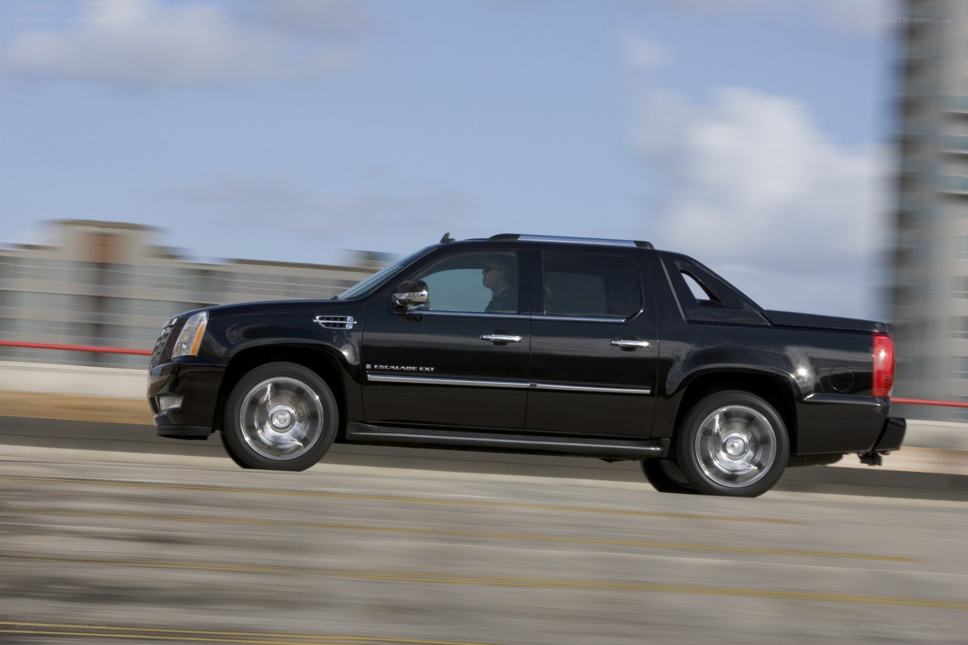 Black Cadillac Escalade EXT in motion