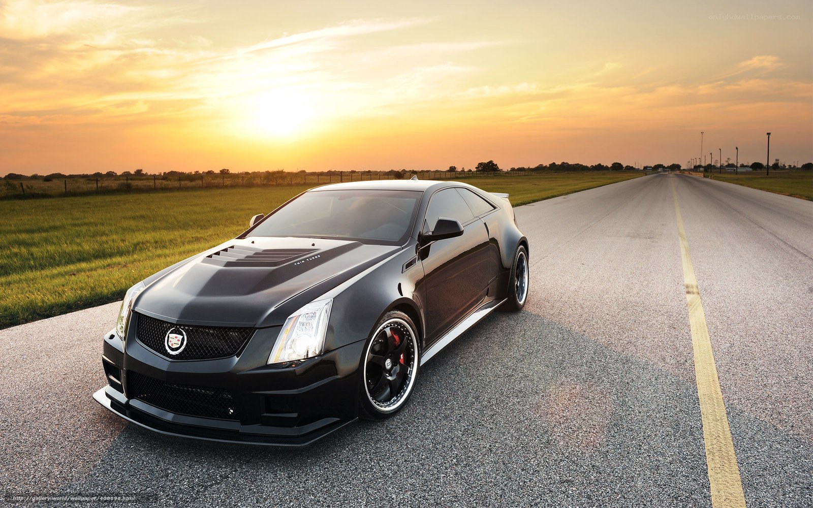 Black Cadillac on a road at sunset