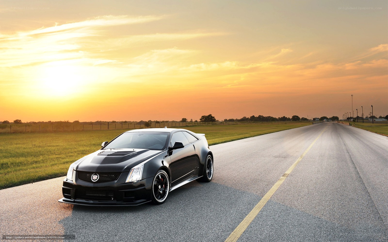 Black Cadillac on a road at sunset