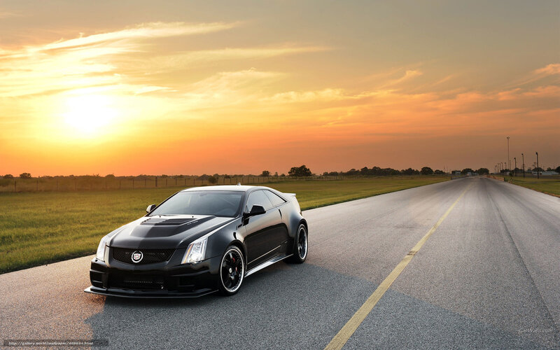 Black Cadillac on a road at sunset