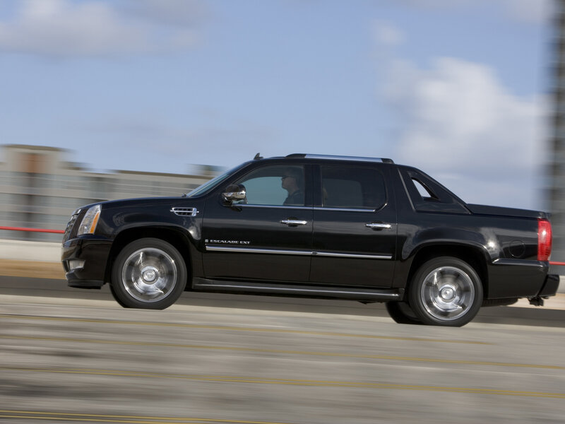 black cadillac pickup truck in motion