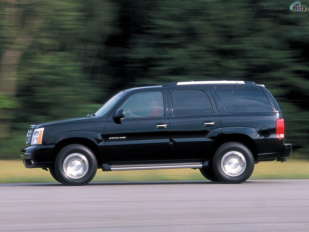 black cadillac suv in motion