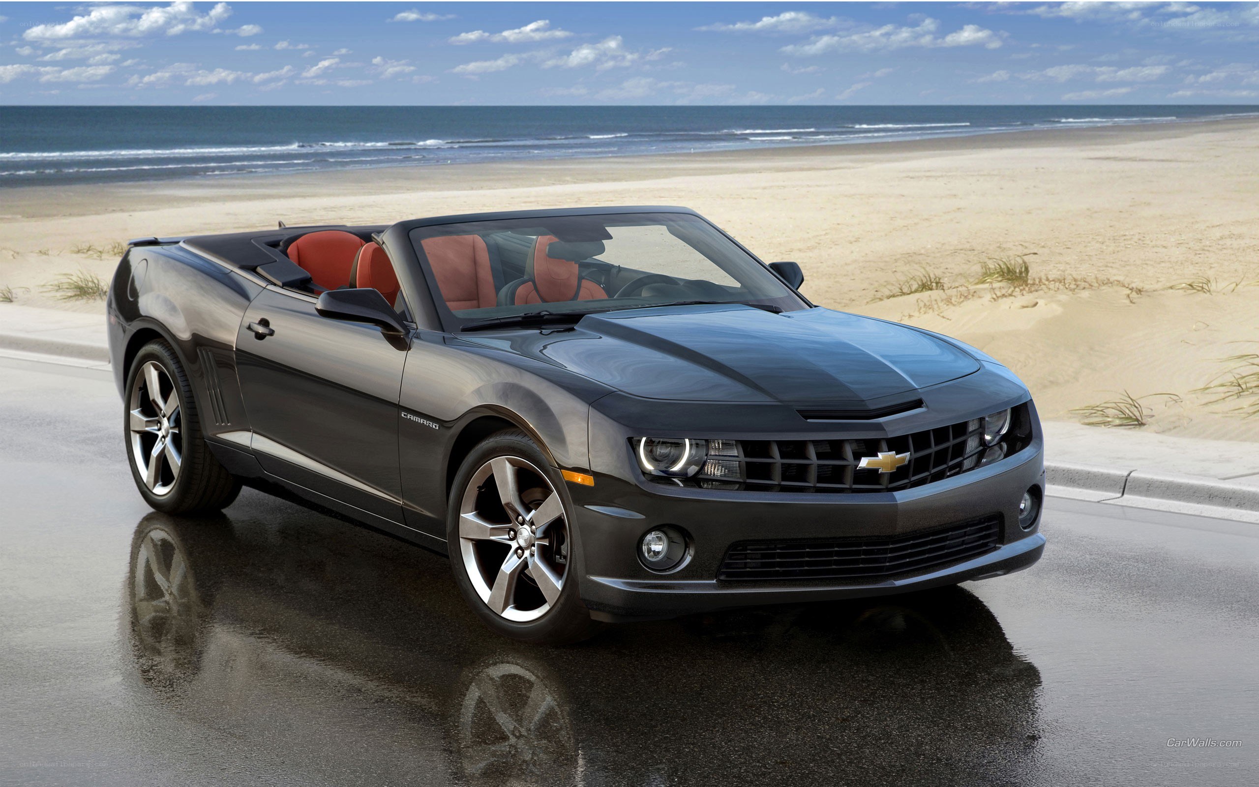 Black Camaro convertible on beach