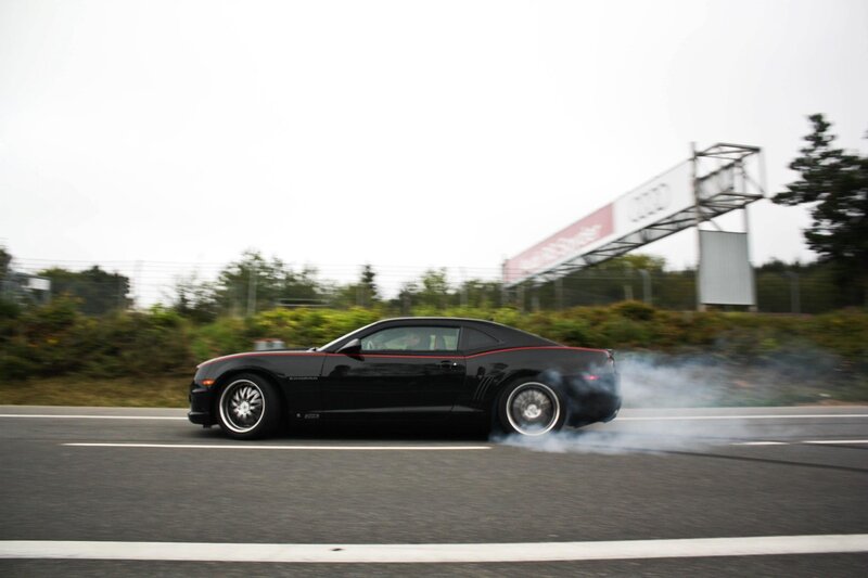 Black Camaro drifting on track