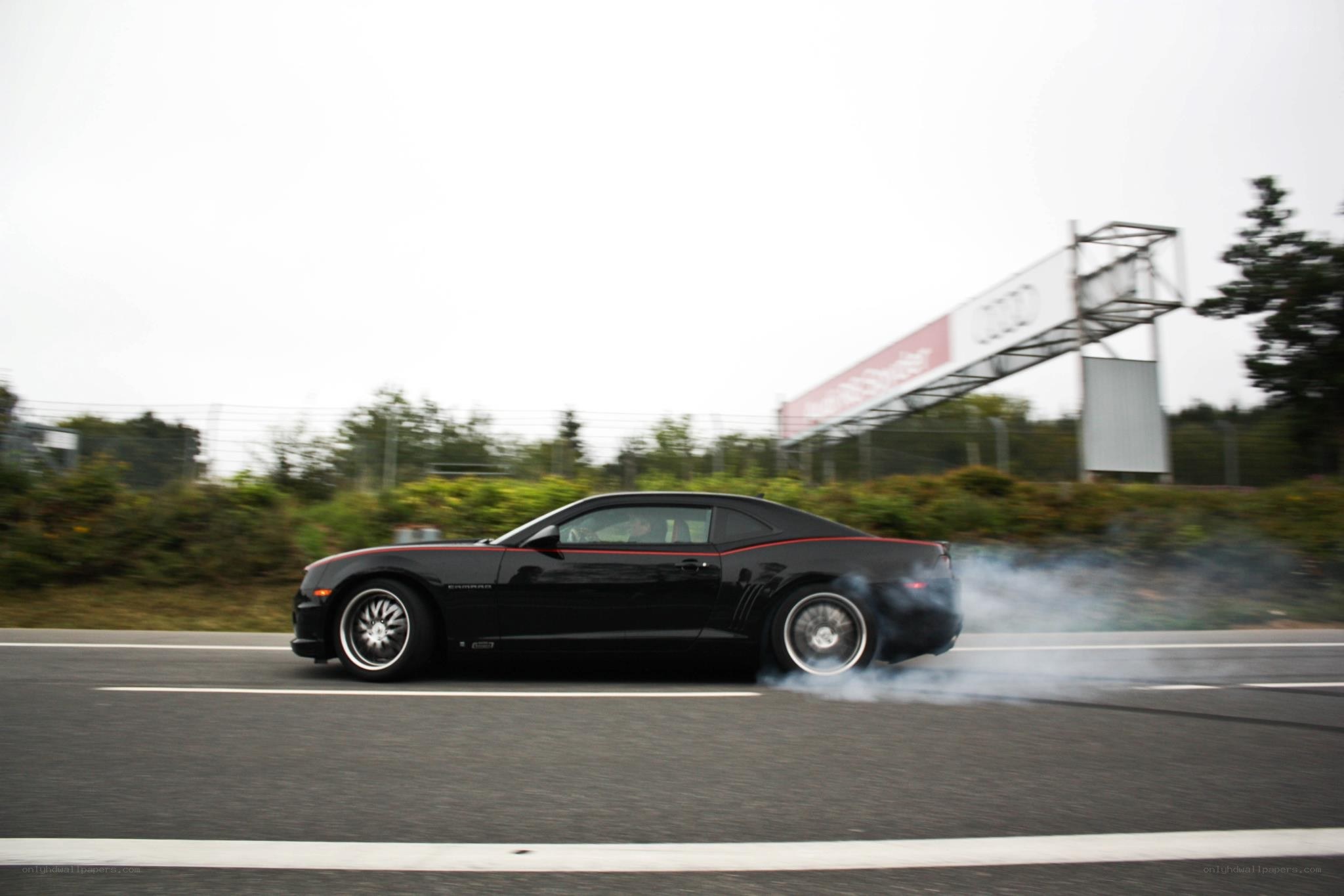 Black Camaro drifting on track