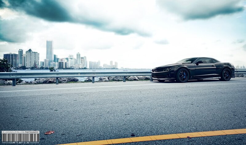 Black Camaro on coastal road