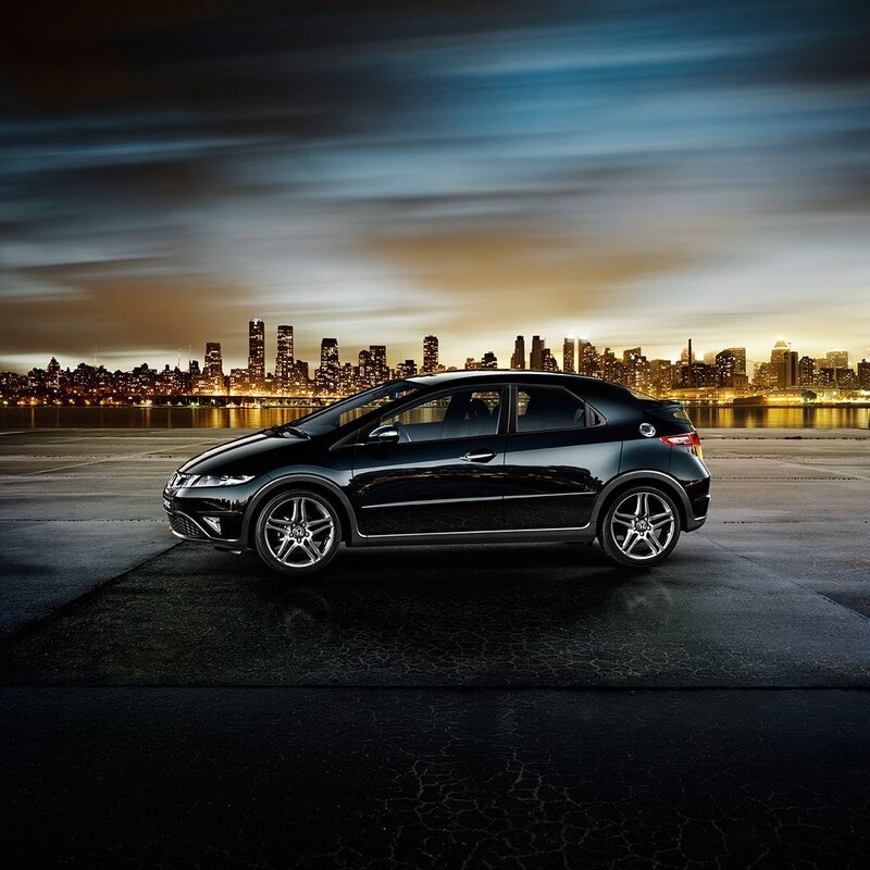 Black car at night with city skyline