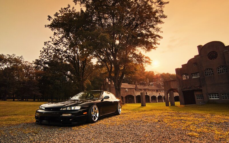 Black car at sunset by old building