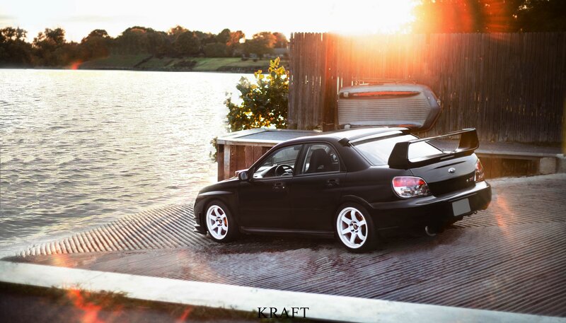 Black car at sunset by the water