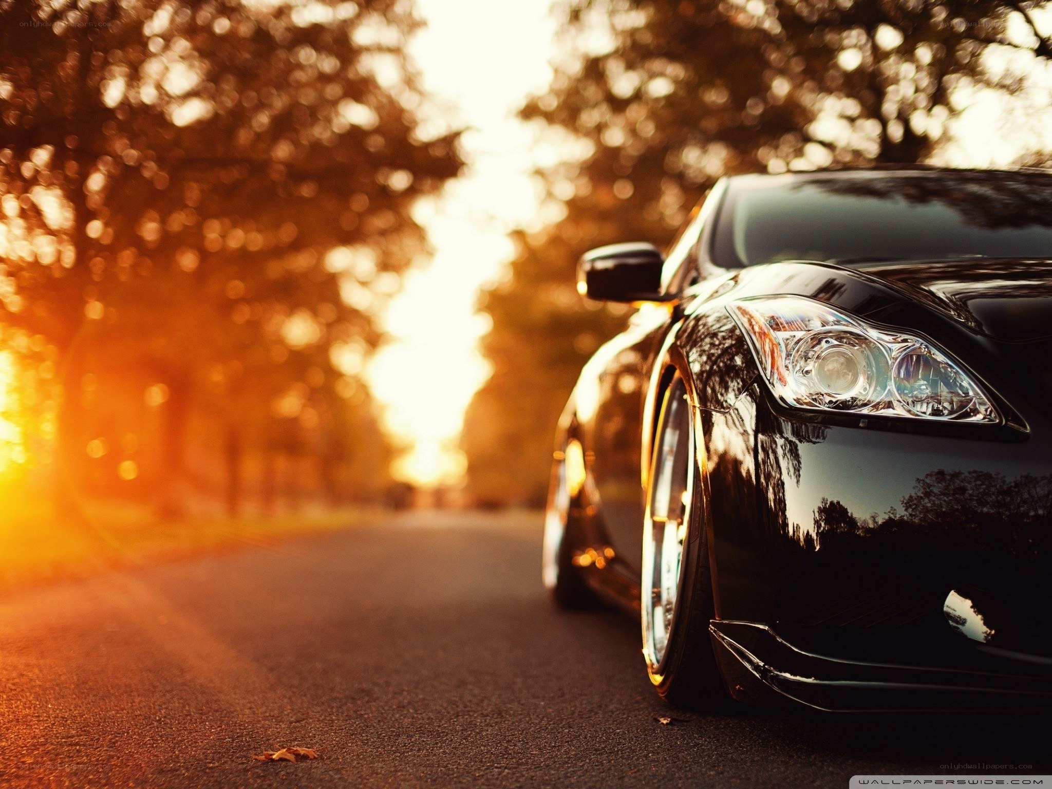 Black car at sunset on road