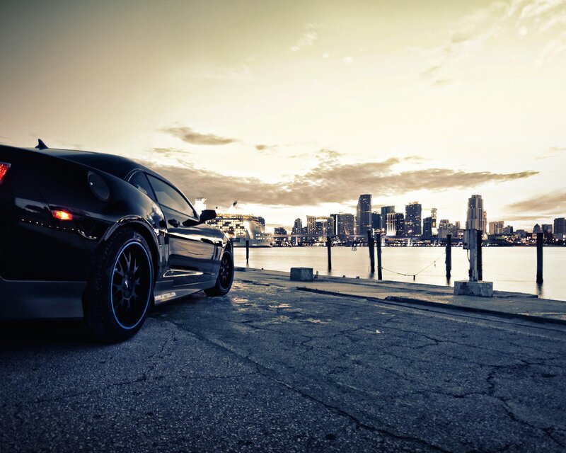 Black car at waterfront sunset