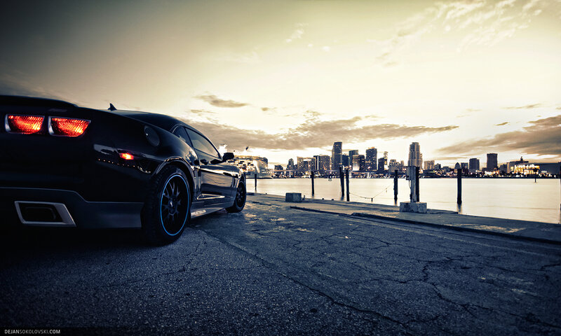 Black car at waterfront sunset