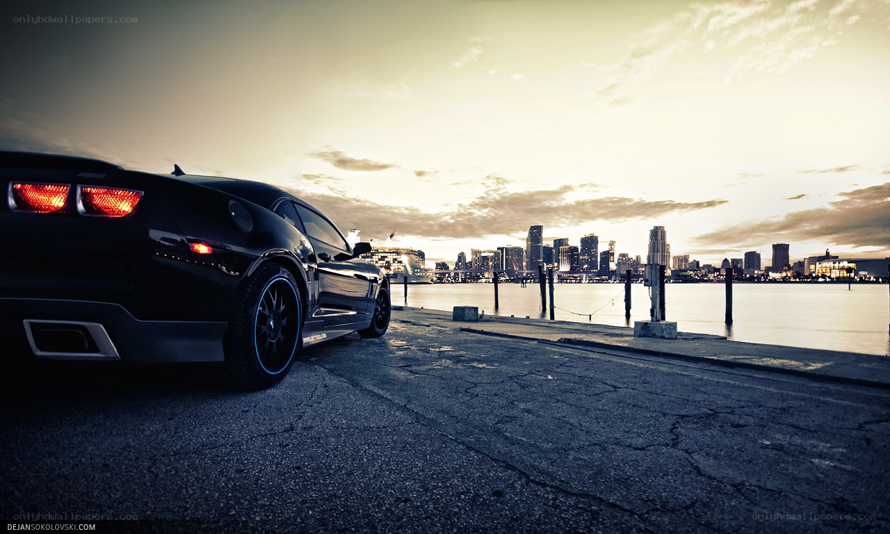 Black car at waterfront sunset