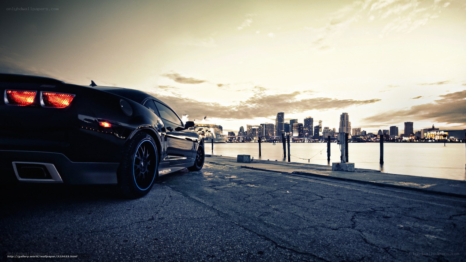 Black car at waterfront sunset
