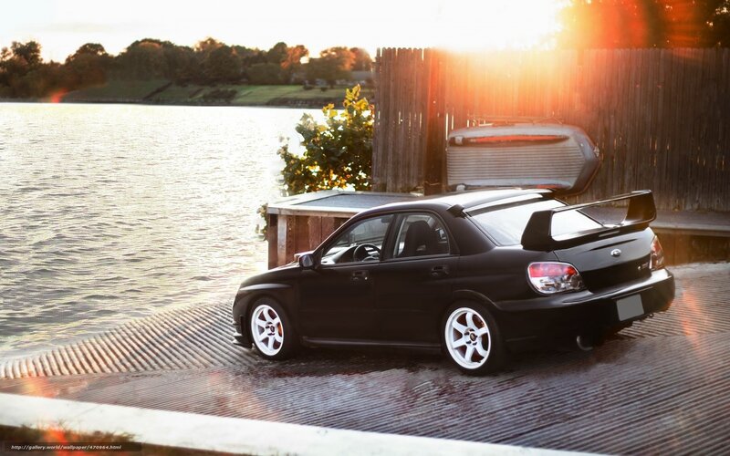 Black car by the lake at sunset