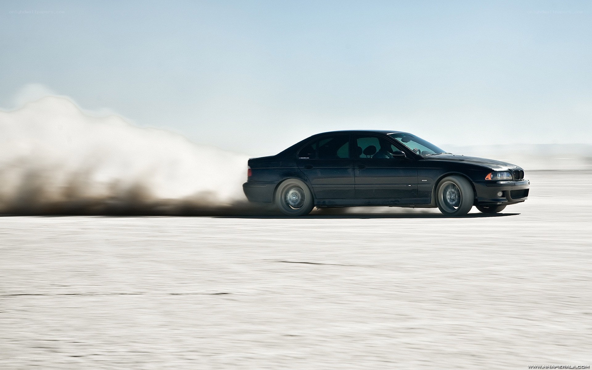 Black car drifting on salt flat
