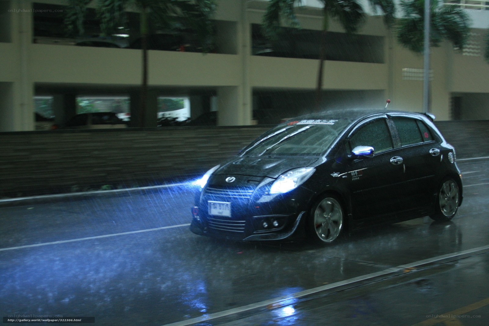 Black car driving in rain